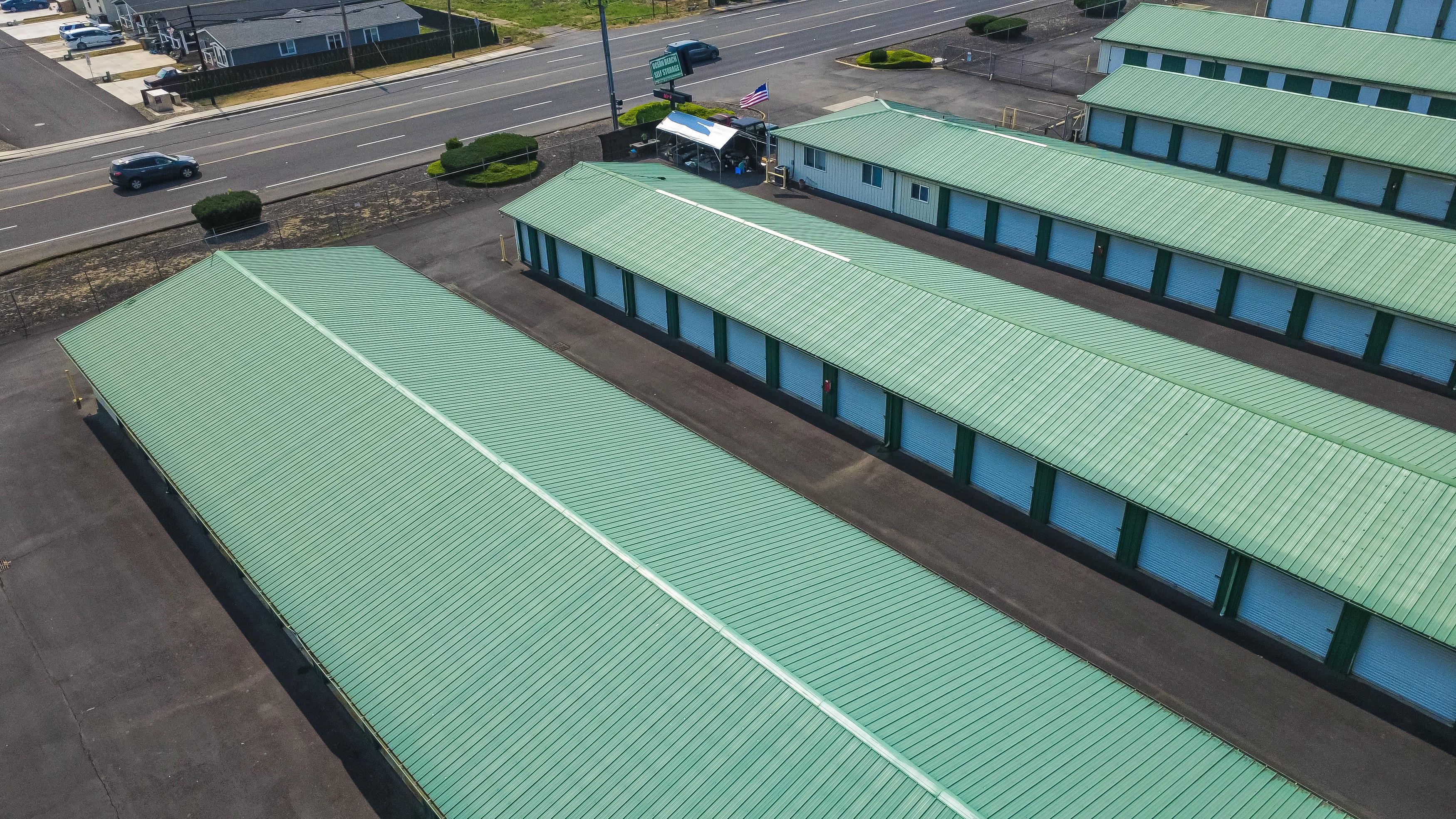 Aerial view of green-roofed storage unit rows and wide paved aisles at Ocean Beach Self Storage in West Longview